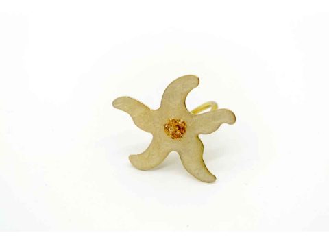 Handmade ring on a gold base, in the shape of a starfish and off-white color.