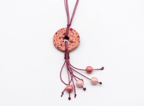 Handmade long necklace with ceramic elements on rotten apple