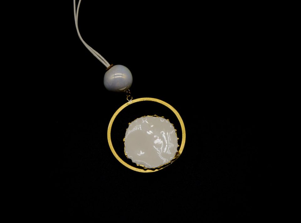 long necklace with forged round element in gold with white enamel