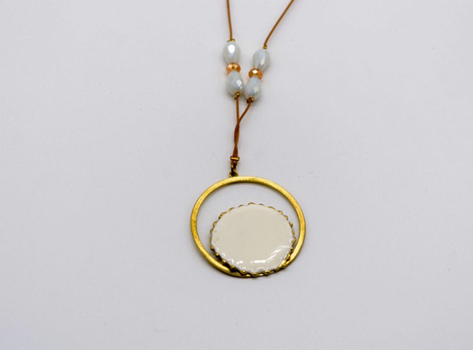 long necklace with forged round element in gold with white enamel