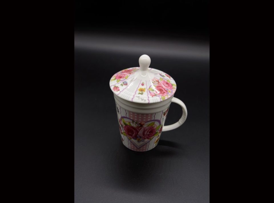 Porcelain mug with lid and heart strainer with roses on rotten apple