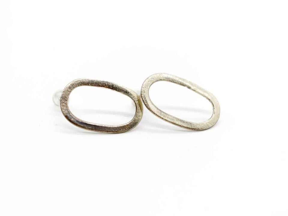 Handmade forged earring glued oval perforated silver.