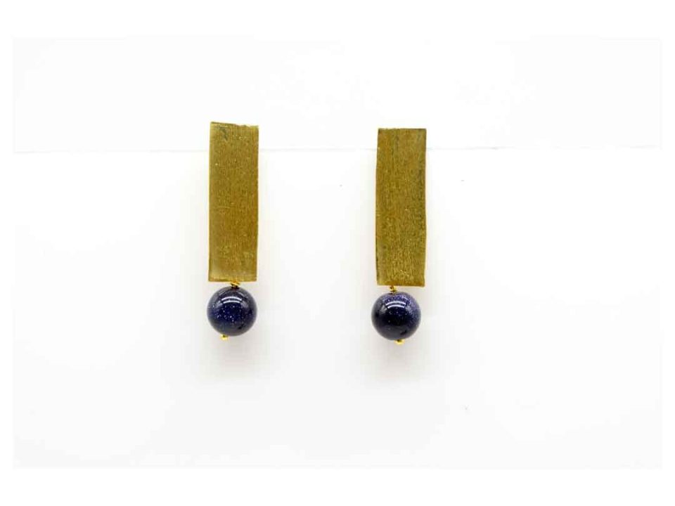 Handmade forged earring nailed in the shape of a gold rod with blue chrysolite.