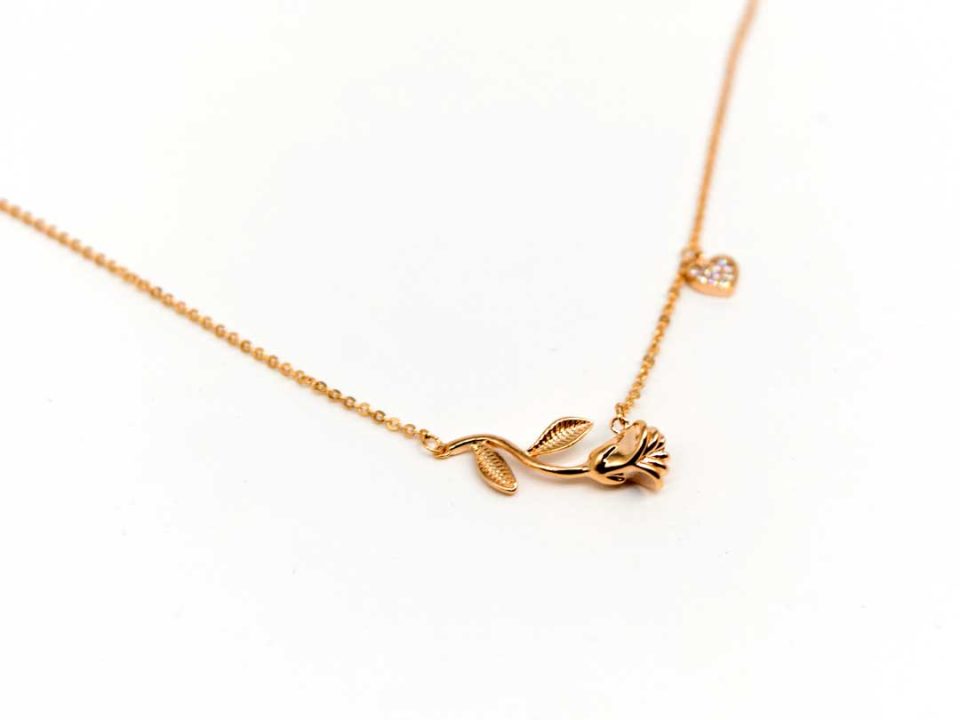 Short steel necklace in rose gold with a rose and a rhinestone heart.