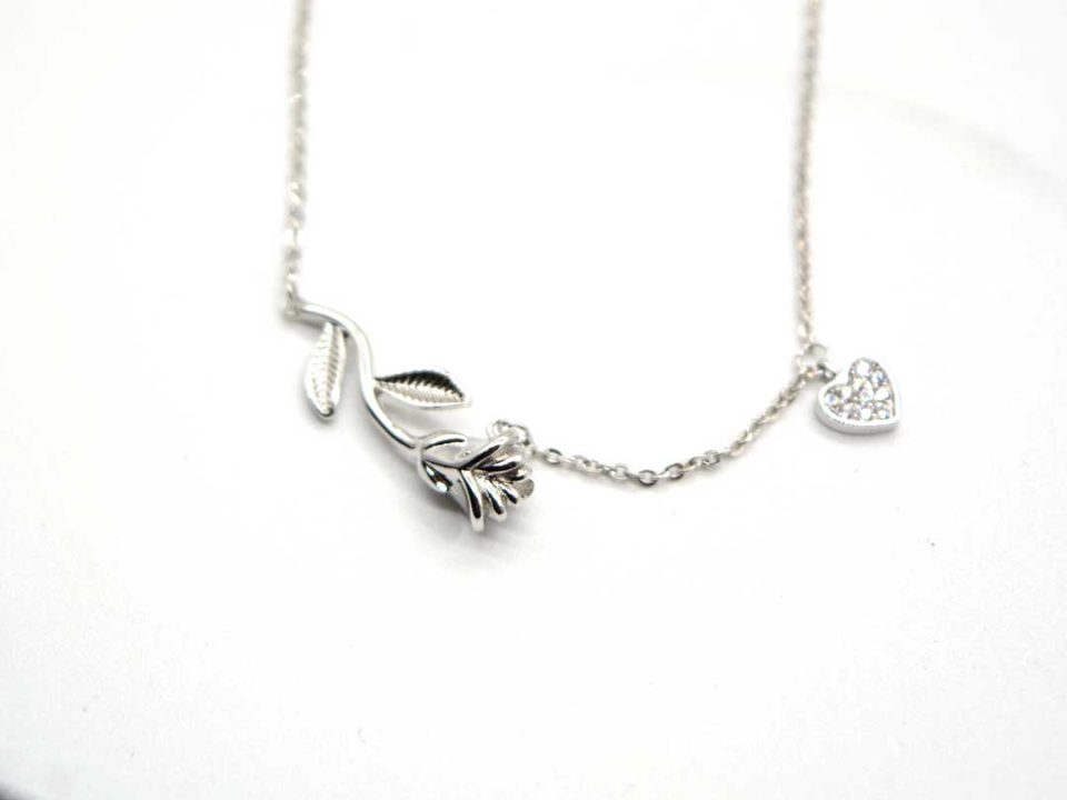 Short steel necklace in silver color a rose and a rhinestone heart.