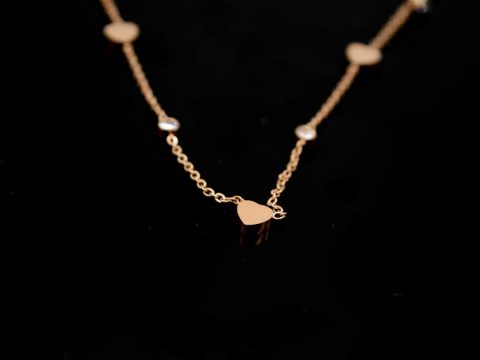 Short steel necklace in rose gold color with hearts and rhinestones.