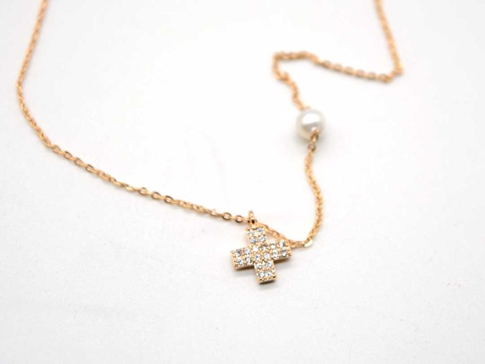 Short steel necklace in rose gold color with rhinestone cross and a pearl