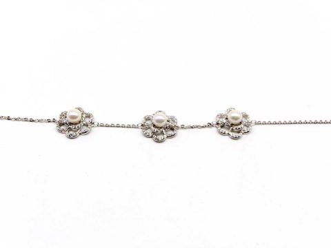 Steel bracelet in silver color with three large flowers with rhinestones and pearl.