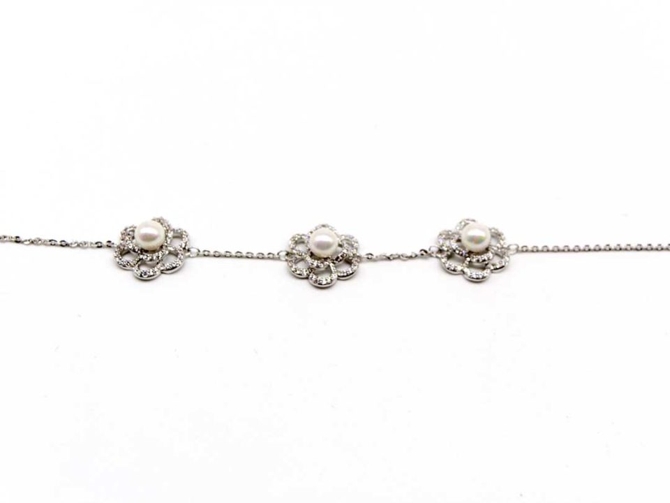 Steel bracelet in silver color with three large flowers with rhinestones and pearl.