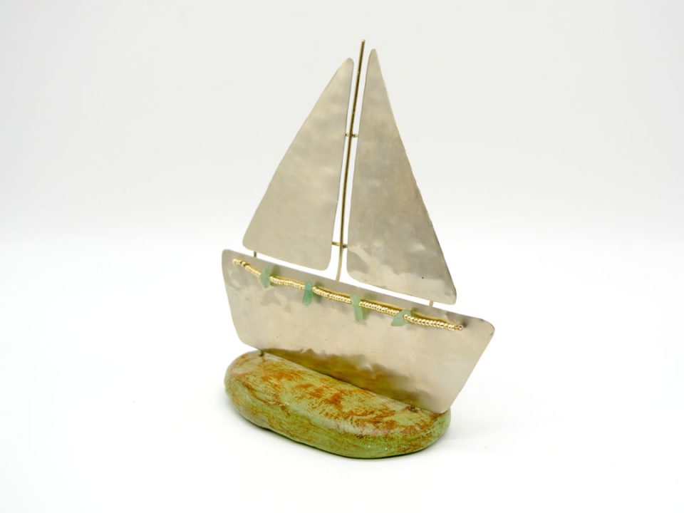 alpaca boat in silver color on a base of green clay.