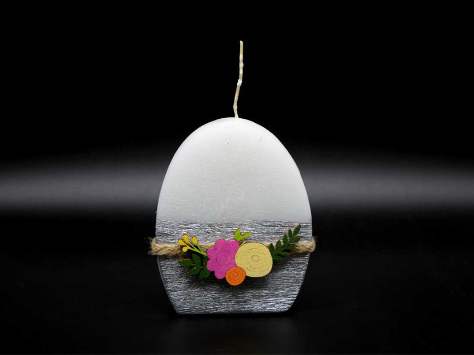 Handmade aromatic candle flat egg on white with silver color with wooden painted flower