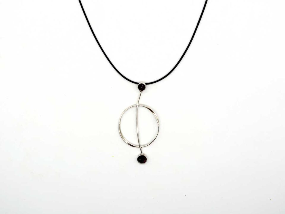 necklace with forged round element with a bar and black pebbles