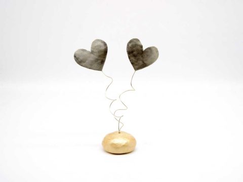 Handmade metal forged hearts silver on a clay base