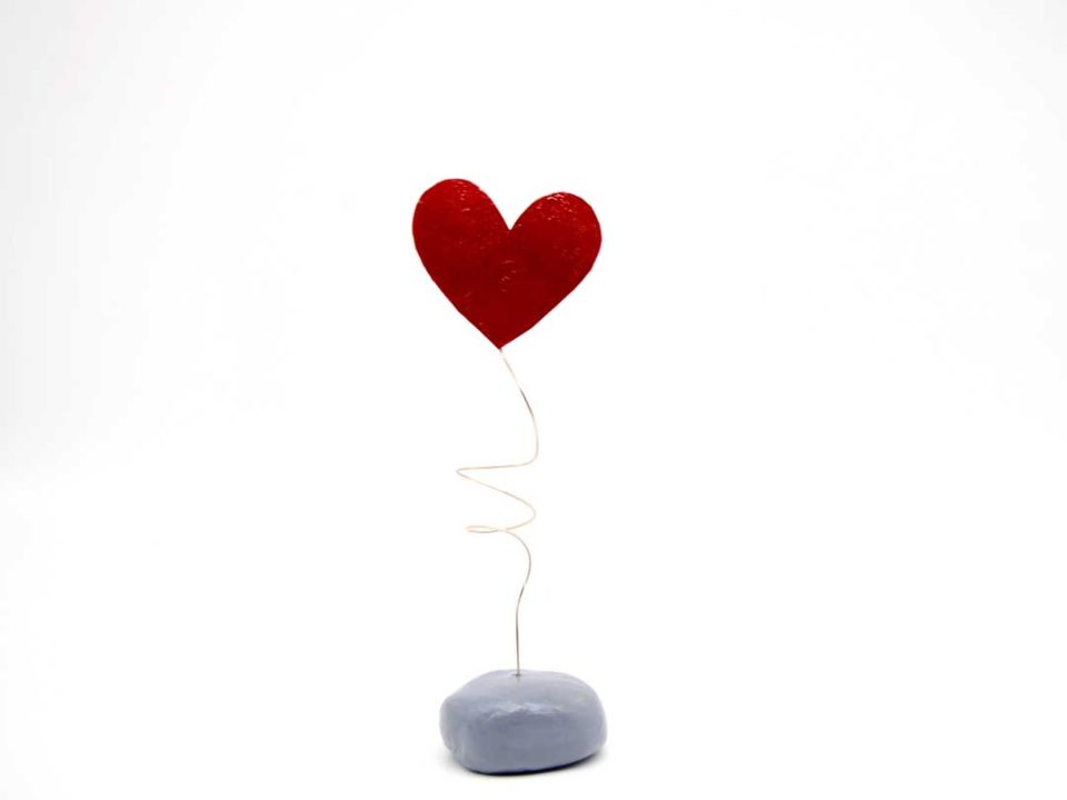 Handmade forged heart painted in red on a clay base