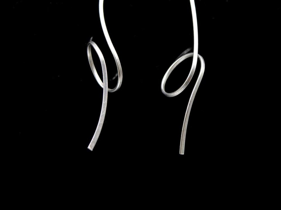 Handmade long forged earring in silver, turned.