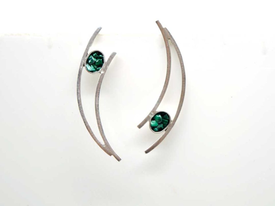 Handmade forged earring in silver different from each other like a crescent with oils.